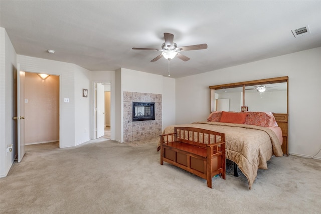 carpeted bedroom with a fireplace, visible vents, and a ceiling fan