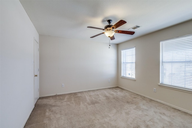 empty room with ceiling fan, carpet flooring, and visible vents