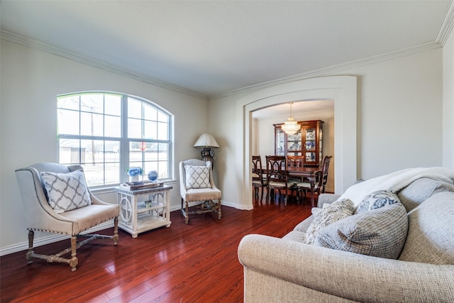 living area featuring crown molding, baseboards, and wood finished floors