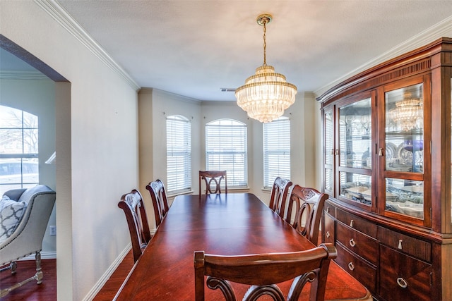 dining space with visible vents, crown molding, an inviting chandelier, and wood finished floors