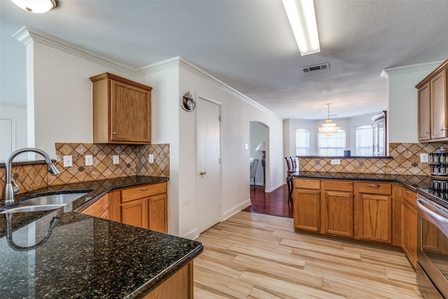 kitchen with visible vents, arched walkways, a peninsula, stainless steel range with electric cooktop, and a sink