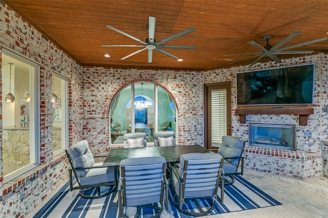 view of patio with an outdoor brick fireplace, outdoor dining area, and a ceiling fan