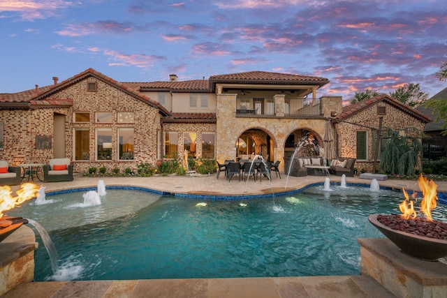 exterior space featuring an outdoor living space with a fire pit, a ceiling fan, and a patio