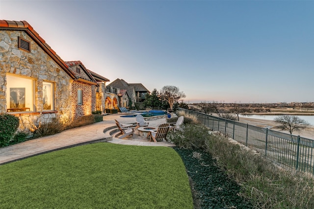 view of yard featuring a patio area, a fenced backyard, a fenced in pool, and a water view