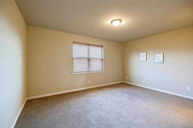 spare room with carpet and baseboards