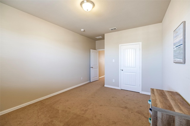 unfurnished bedroom with baseboards, visible vents, and carpet flooring