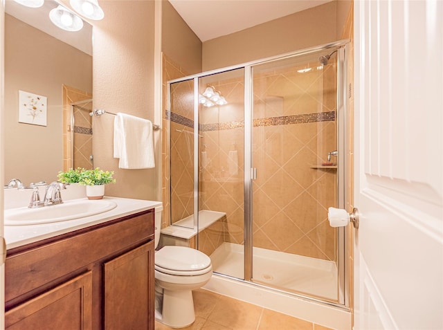 bathroom featuring vanity, tile patterned flooring, toilet, and a shower stall