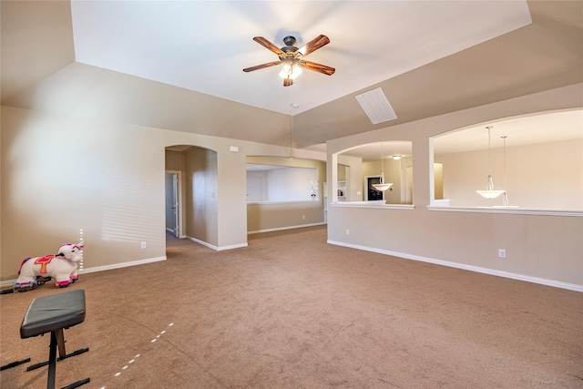 interior space featuring arched walkways, carpet flooring, a ceiling fan, baseboards, and vaulted ceiling