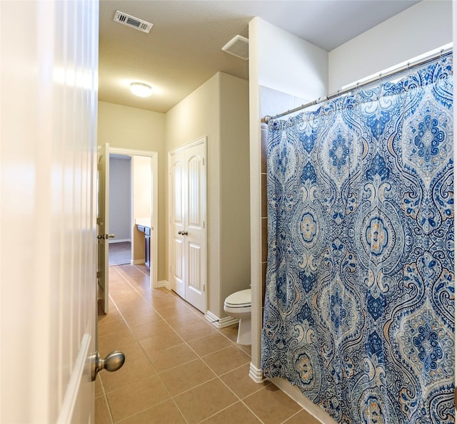 bathroom with baseboards, visible vents, toilet, tile patterned floors, and curtained shower