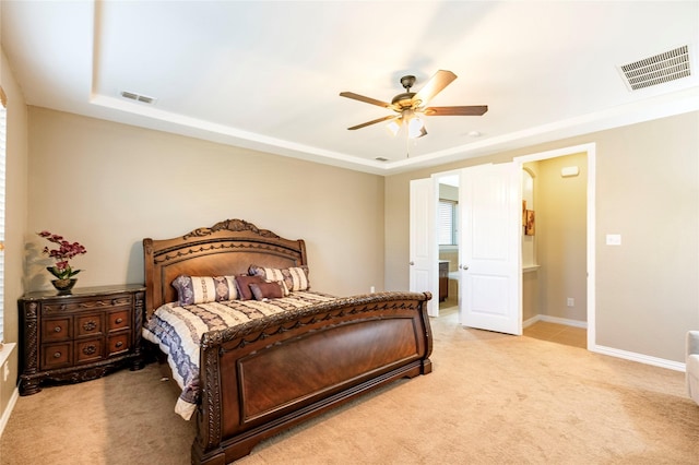 bedroom with light carpet, a tray ceiling, and visible vents