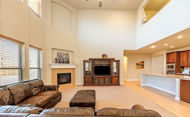 living area featuring a fireplace, light tile patterned floors, recessed lighting, light colored carpet, and ceiling fan