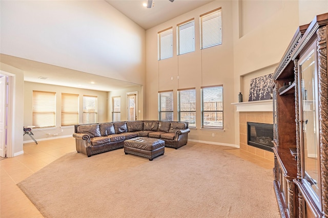 carpeted living area with tile patterned floors, baseboards, and a tile fireplace