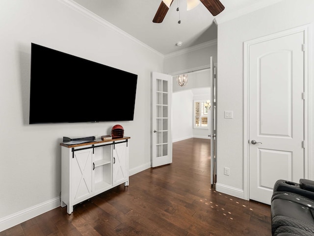 living area with french doors, crown molding, dark wood-type flooring, baseboards, and ceiling fan with notable chandelier