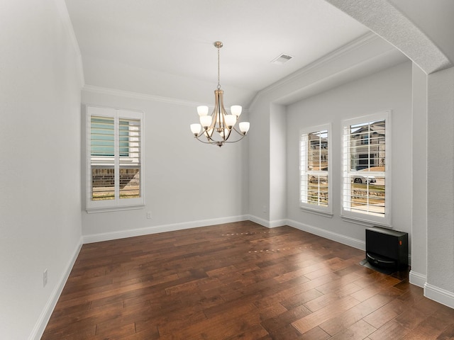 spare room with a wealth of natural light, dark wood finished floors, visible vents, and baseboards