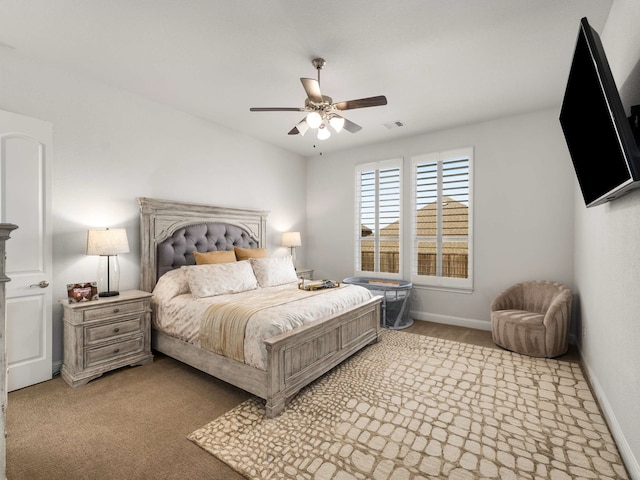 carpeted bedroom with baseboards, visible vents, and a ceiling fan