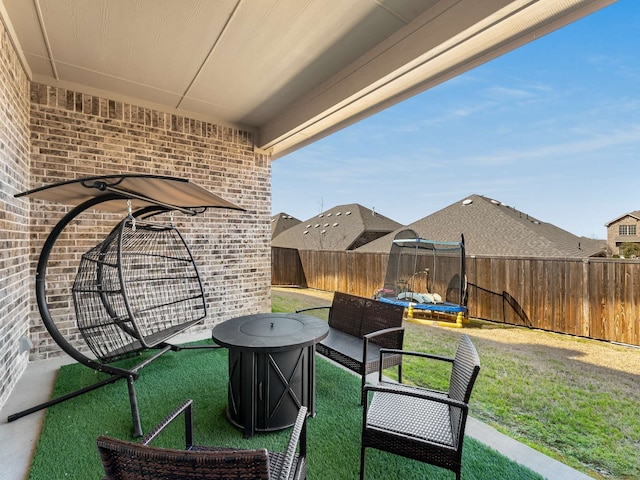 view of patio with a trampoline, a fenced backyard, and an outdoor living space