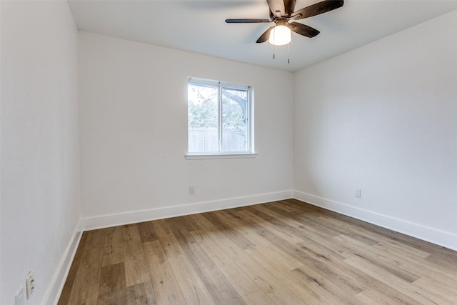 empty room featuring a ceiling fan, baseboards, and wood finished floors