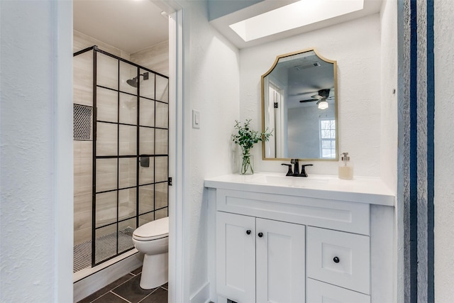 bathroom featuring a skylight, visible vents, toilet, a shower stall, and vanity