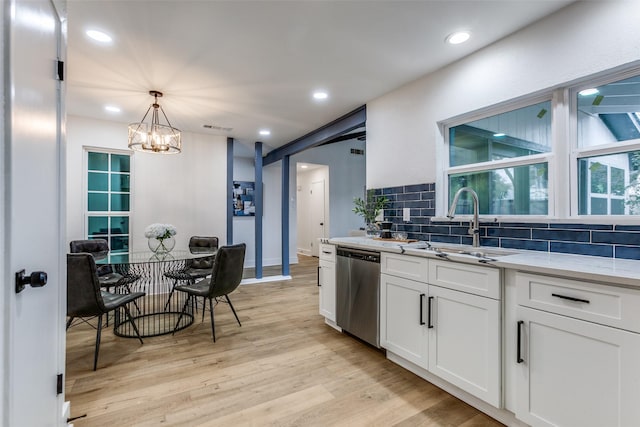 kitchen with tasteful backsplash, light wood-style floors, white cabinetry, a sink, and dishwasher