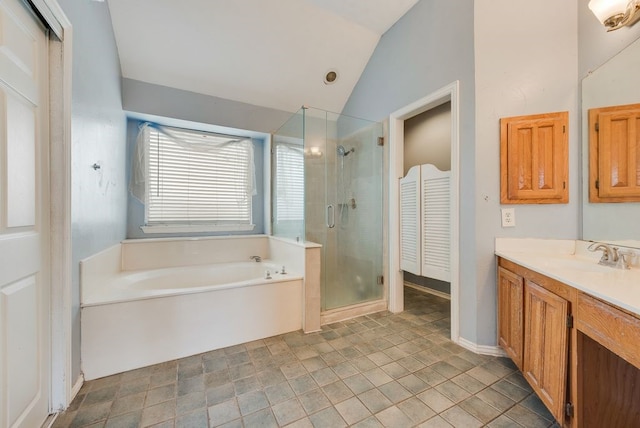 bathroom featuring a garden tub, a shower stall, vaulted ceiling, and vanity