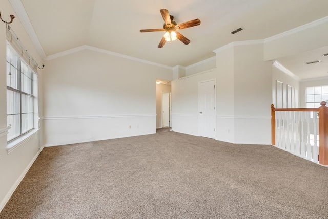 empty room with lofted ceiling, carpet, visible vents, and crown molding