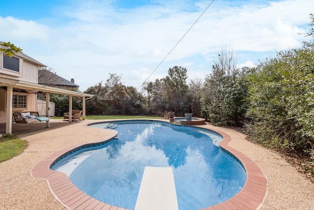 view of swimming pool featuring a pool with connected hot tub, a patio area, and a diving board