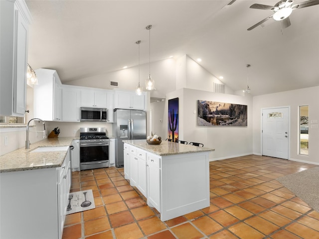 kitchen featuring white cabinets, stainless steel appliances, a sink, and a center island