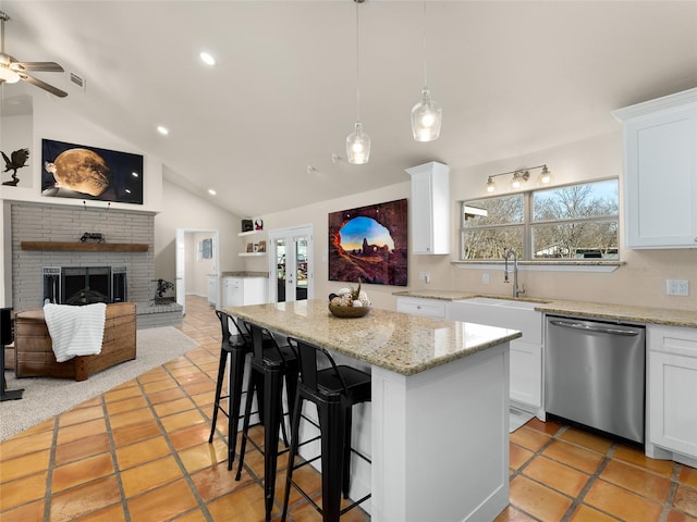 kitchen featuring dishwasher, lofted ceiling, a kitchen island, open floor plan, and a sink