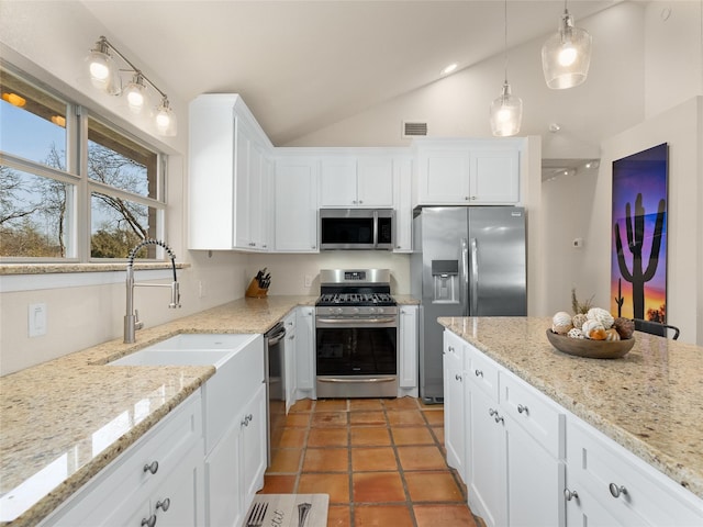 kitchen with visible vents, appliances with stainless steel finishes, white cabinets, vaulted ceiling, and a sink