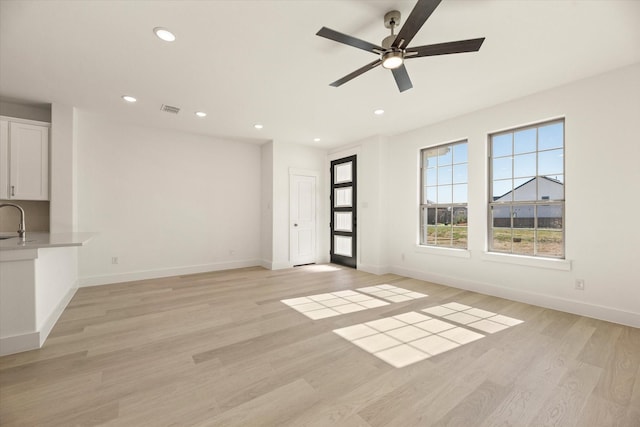 unfurnished living room featuring baseboards, light wood-style flooring, visible vents, and recessed lighting