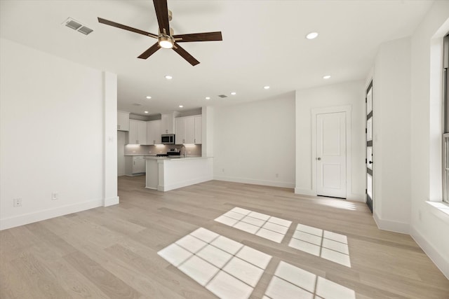 unfurnished living room with baseboards, light wood finished floors, visible vents, and recessed lighting