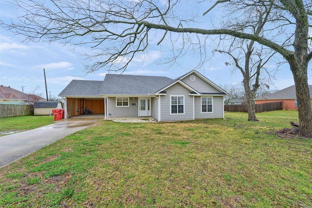 ranch-style home with an attached carport, fence, driveway, and a front lawn