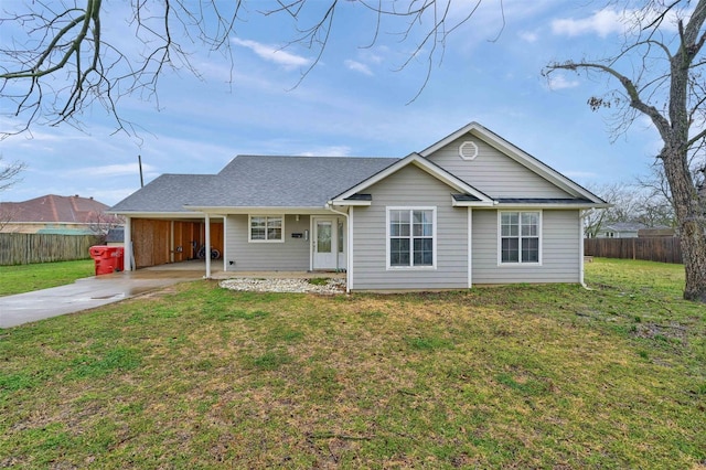 ranch-style house with an attached carport, concrete driveway, fence, and a front yard