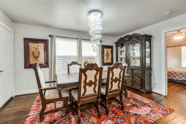 dining room with a notable chandelier, dark wood-type flooring, and baseboards