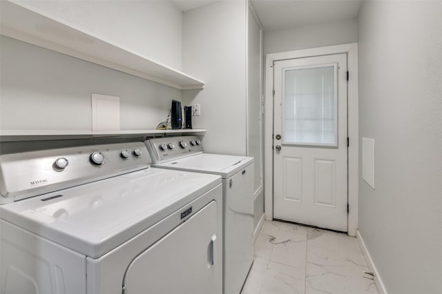 laundry room with laundry area, marble finish floor, washer and dryer, and baseboards