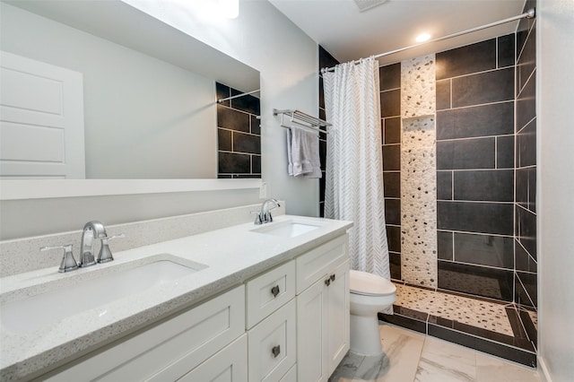 full bathroom with double vanity, toilet, a stall shower, and a sink