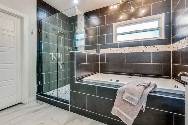 bathroom featuring a garden tub, a stall shower, and marble finish floor