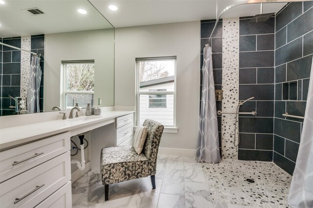 bathroom featuring a tile shower, plenty of natural light, marble finish floor, and visible vents