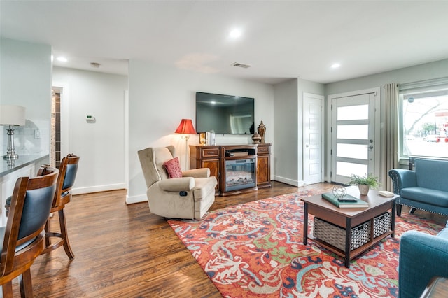 living room featuring recessed lighting, wood finished floors, visible vents, and baseboards