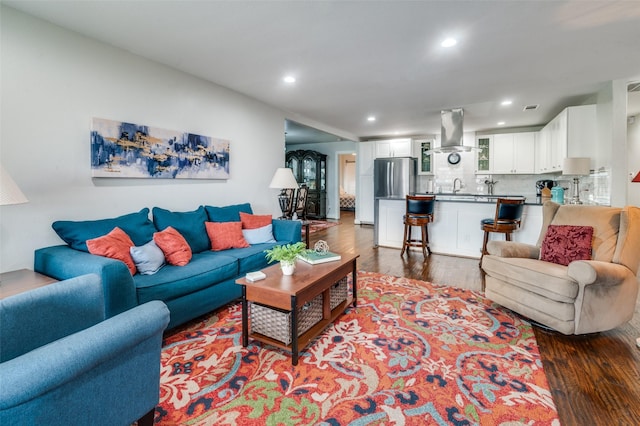 living room with dark wood-style floors and recessed lighting