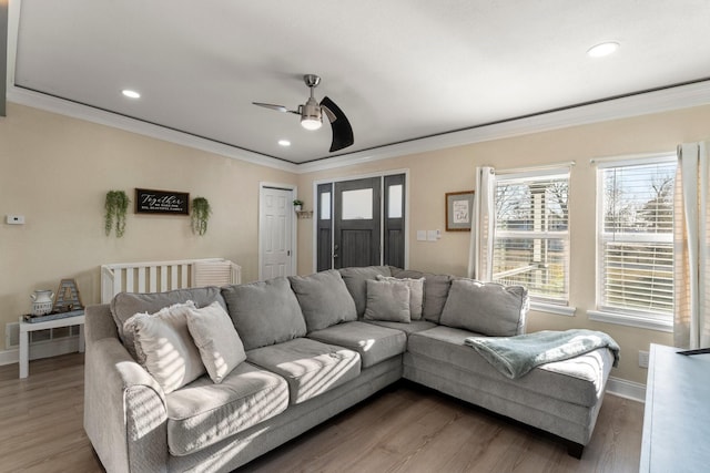 living room with ornamental molding, baseboards, and wood finished floors