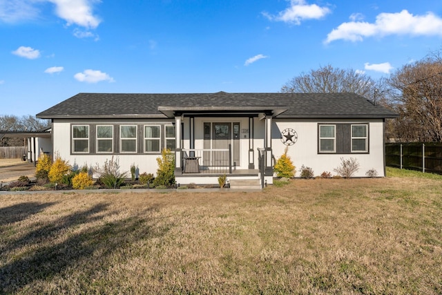 view of front facade featuring roof with shingles, fence, a porch, and a front yard