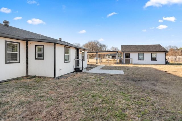 back of house featuring fence and a yard