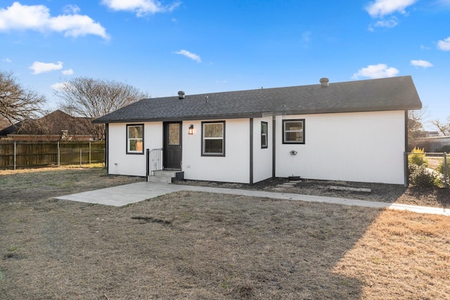 back of house featuring fence and a lawn