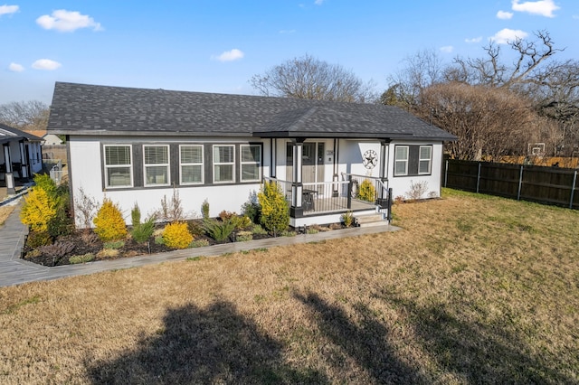 view of front of home with a front lawn, a shingled roof, and fence