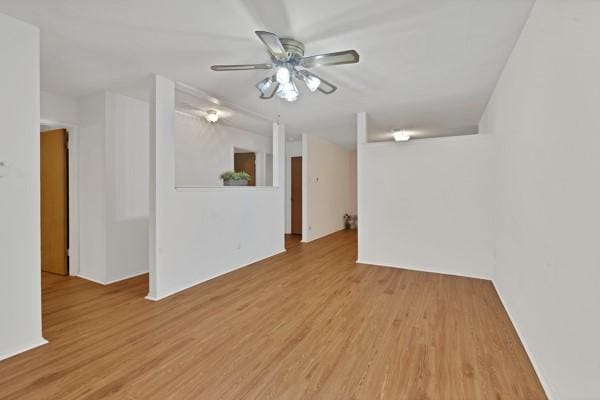 spare room with light wood-type flooring and a ceiling fan