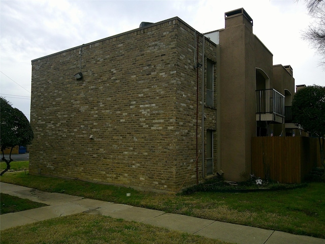 view of home's exterior with a yard and brick siding