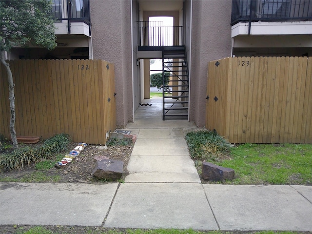 doorway to property with fence and stucco siding