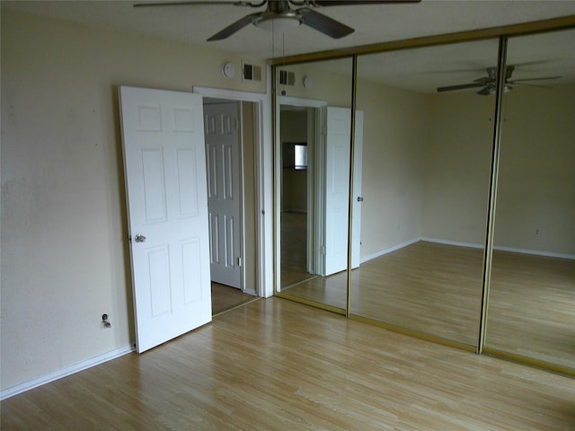 unfurnished bedroom featuring visible vents, ceiling fan, baseboards, and wood finished floors