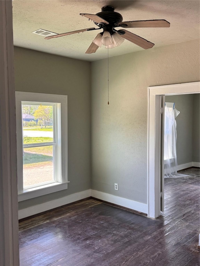 empty room with visible vents, baseboards, wood finished floors, and a textured ceiling